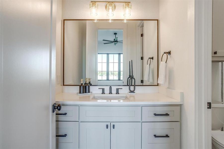 Bathroom with vanity, toilet, and ceiling fan