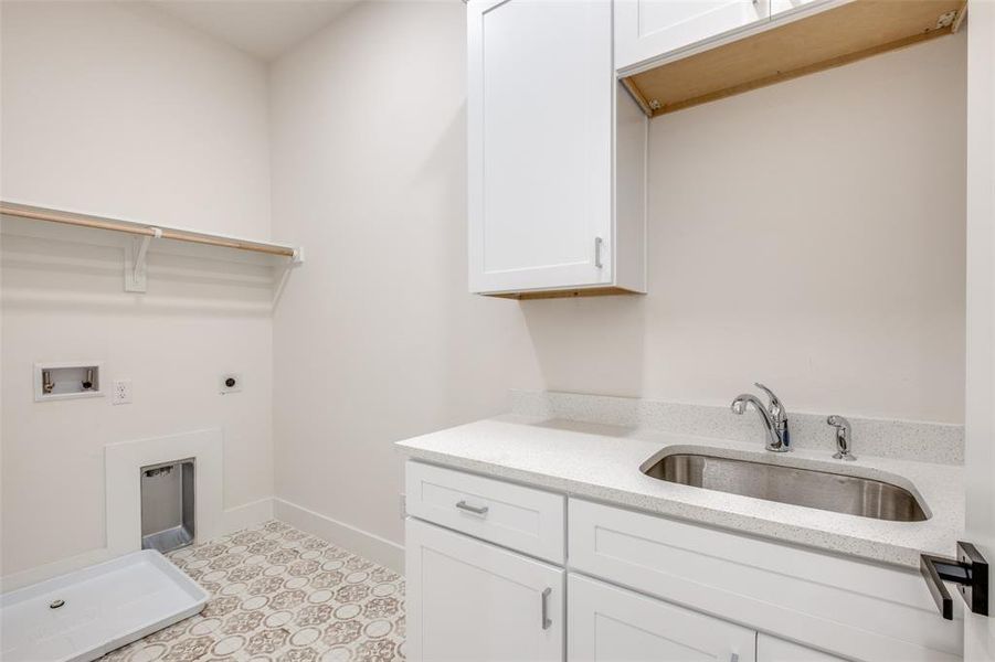 Laundry room with cabinets, electric dryer hookup, hookup for a washing machine, sink, and light tile floors