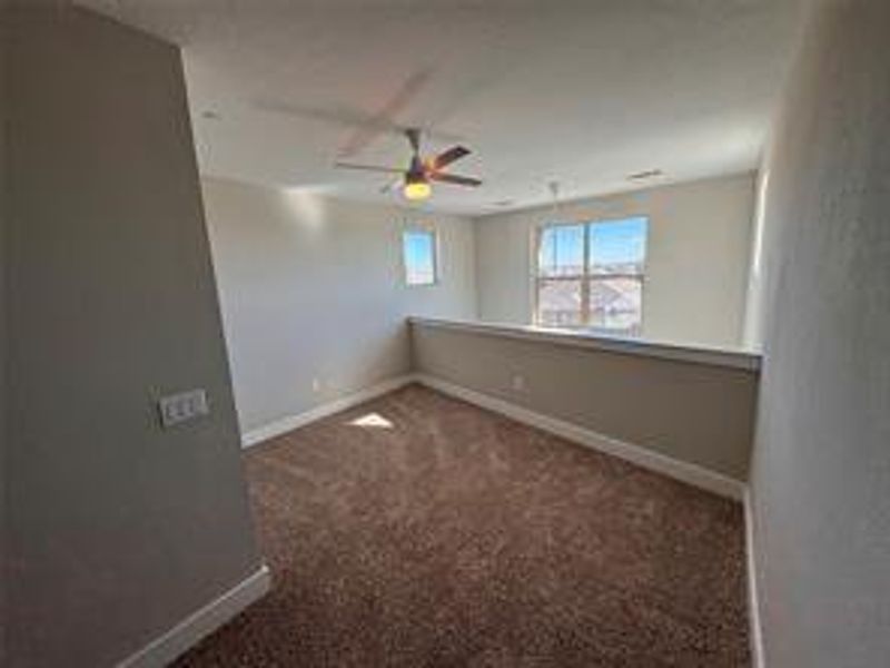 Spare room with ceiling fan and dark carpet