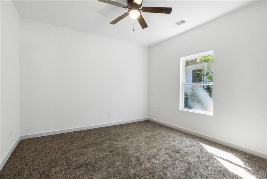 Carpeted spare room with ceiling fan