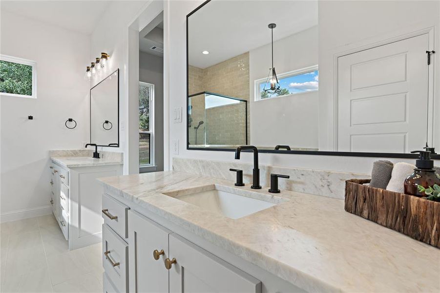 Bathroom featuring vanity, walk in shower, tile patterned floors, and a wealth of natural light