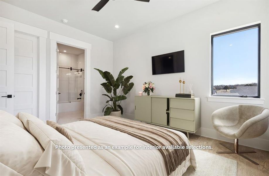 Bedroom featuring ceiling fan, multiple windows, light hardwood / wood-style flooring, and ensuite bath
