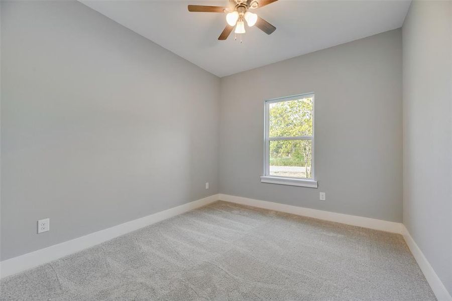 Empty room featuring carpet floors and ceiling fan