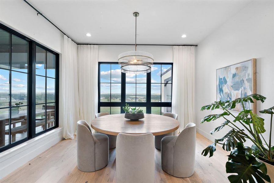 Dining room with plenty of natural light, a chandelier, and light wood-type flooring