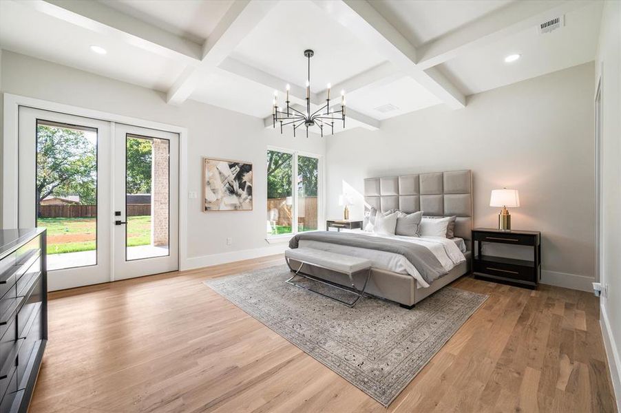 Bedroom featuring multiple windows, coffered ceiling, and access to outside