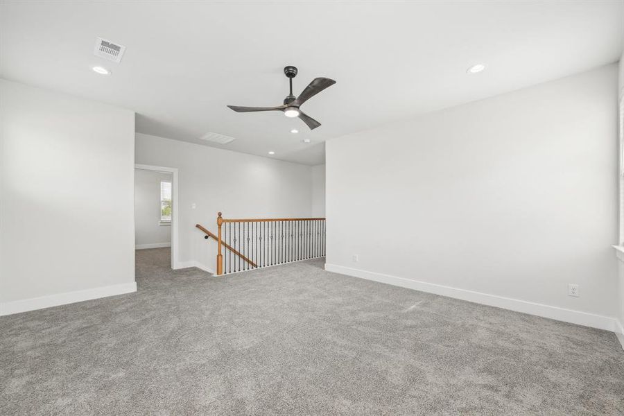 Carpeted empty room featuring ceiling fan