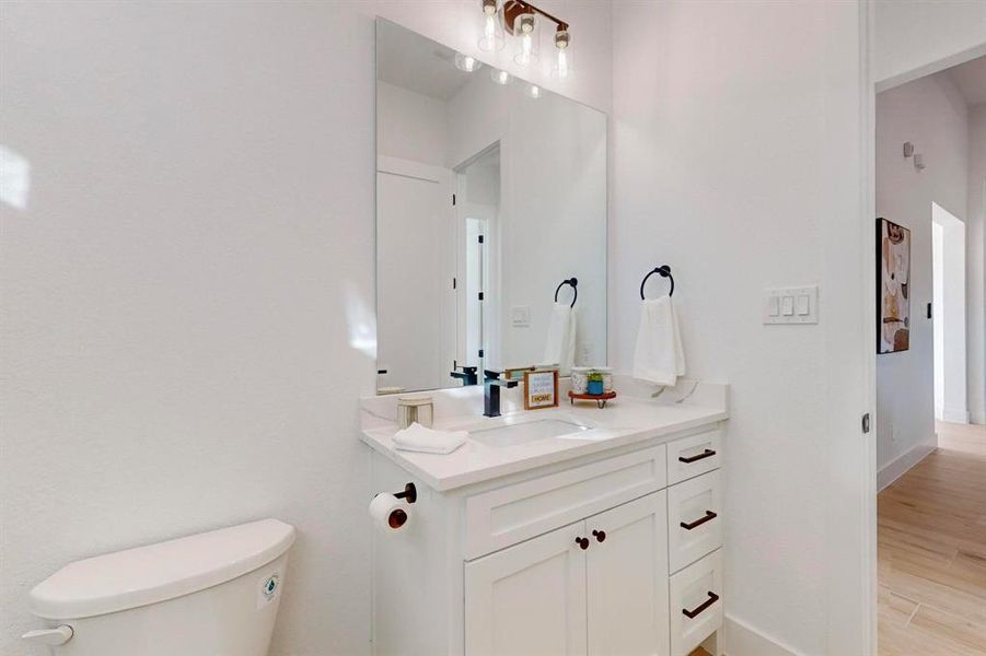 Bathroom featuring hardwood / wood-style floors, vanity, and toilet