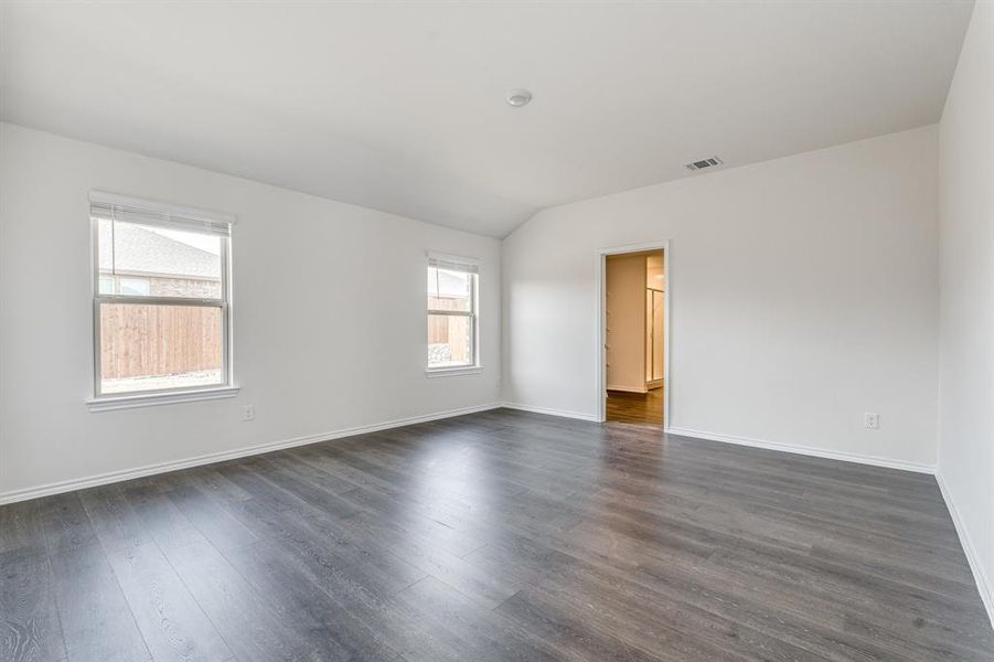 Unfurnished room with lofted ceiling and dark hardwood / wood-style floors