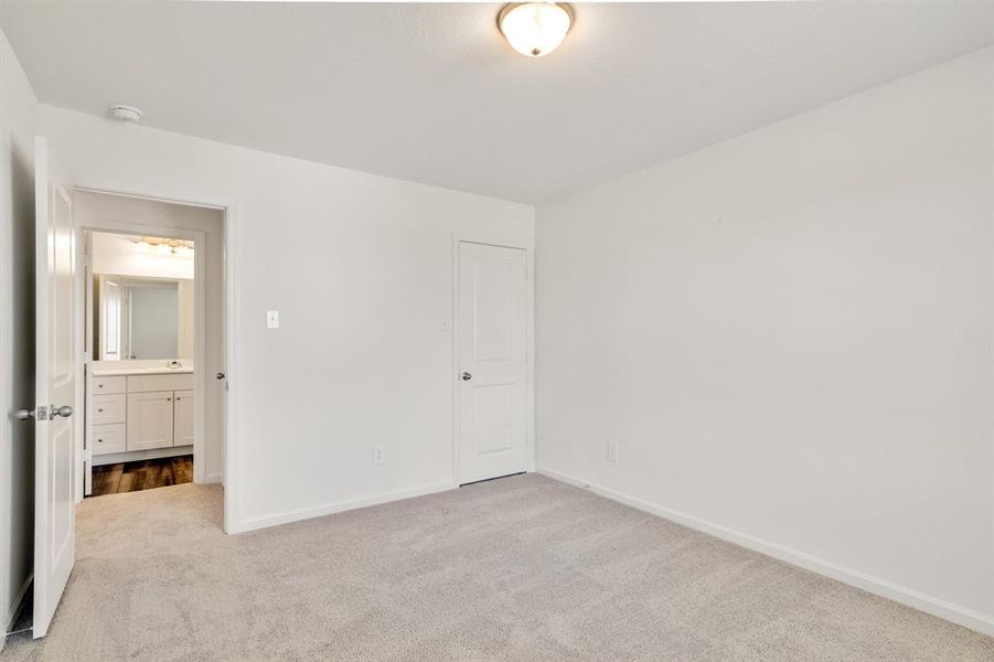 Unfurnished bedroom with light carpet