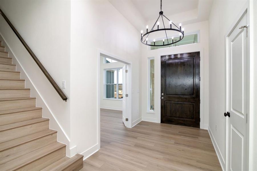 Entrance foyer featuring an inviting chandelier and light wood-type flooring