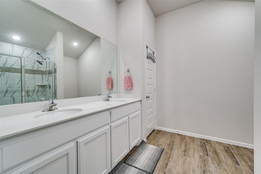 Bathroom featuring vanity, hardwood / wood-style flooring, and walk in shower