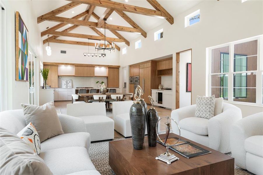 Living room featuring an inviting chandelier, beamed ceiling, and high vaulted ceiling