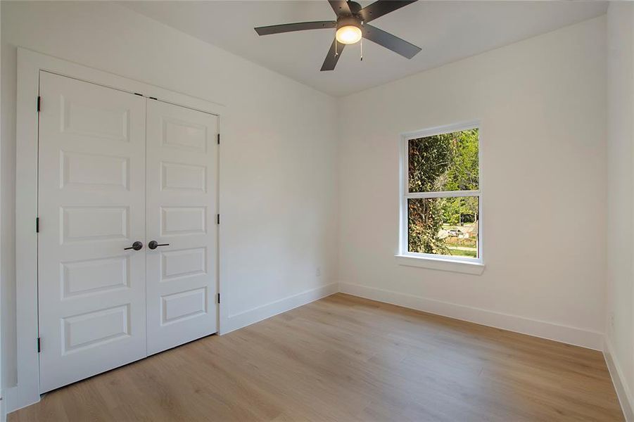 Unfurnished bedroom with a closet, ceiling fan, and light hardwood / wood-style flooring