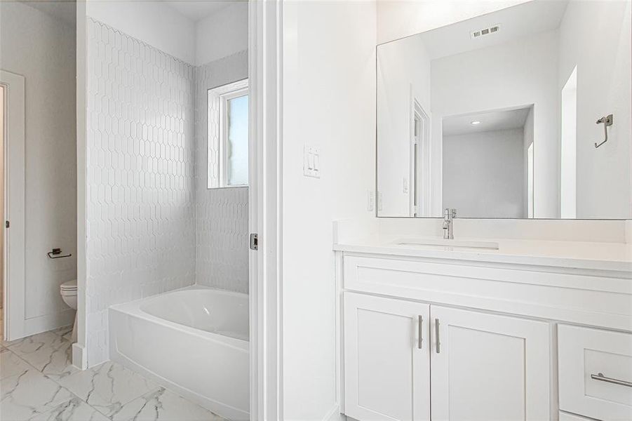 Full bathroom with vanity, toilet, tile patterned floors, and shower / bathing tub combination