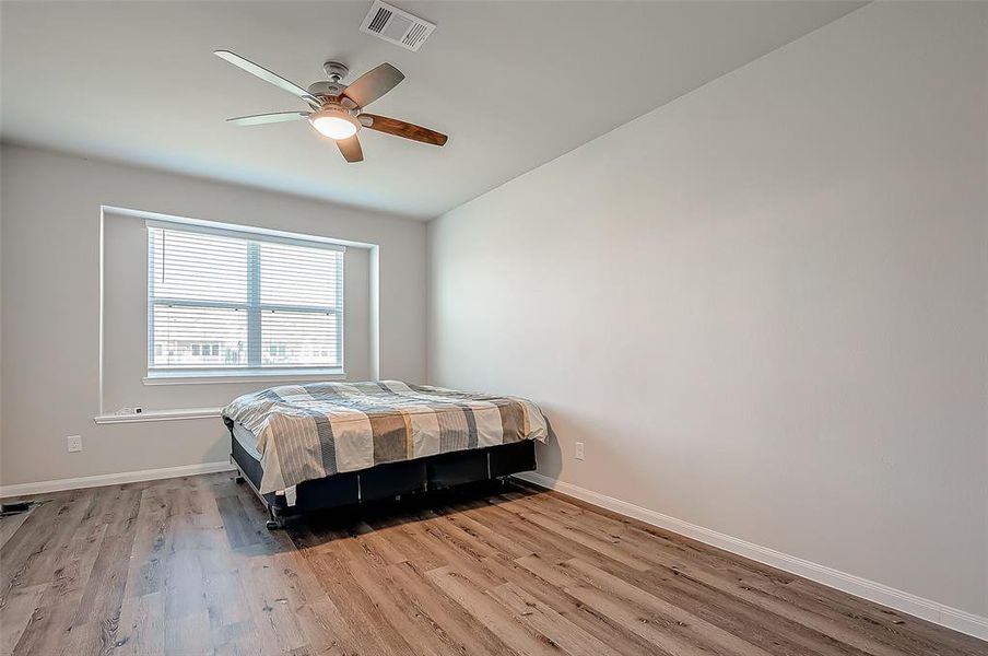 The primary bedroom is a tranquil retreat, complete with windows that provide ample natural light. The ceiling fan adds a refreshing breeze.