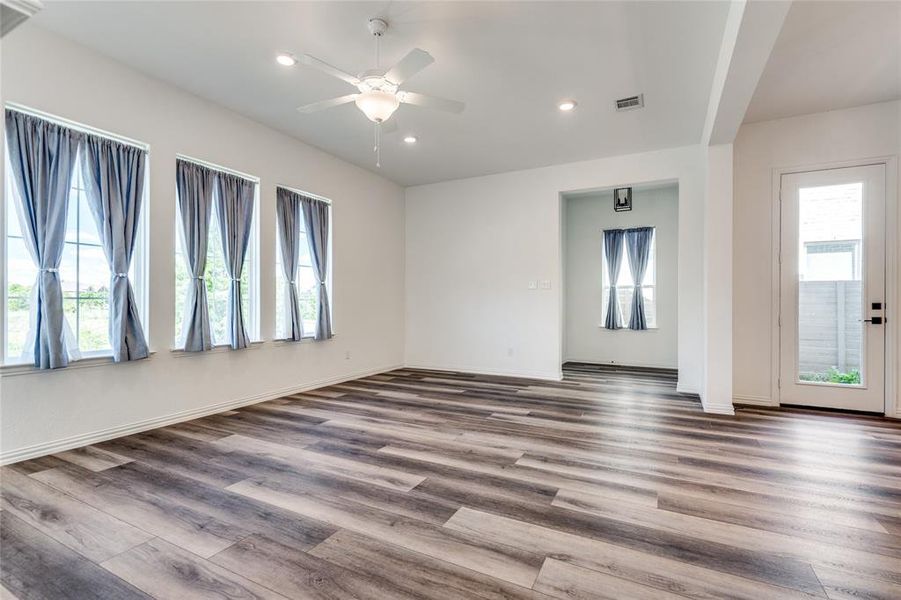 Empty room featuring hardwood / wood-style floors, ceiling fan, and a wealth of natural light