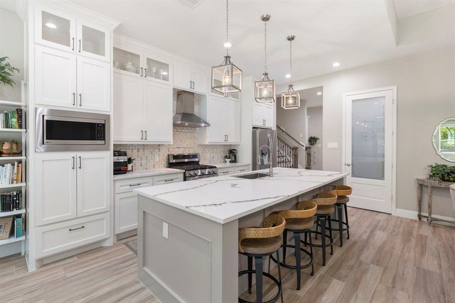 Two-toned island and custom cabinetry in the kitchen creates a high-end appeal. Double-oven hookups are already setup if you want to add one under the microwave.