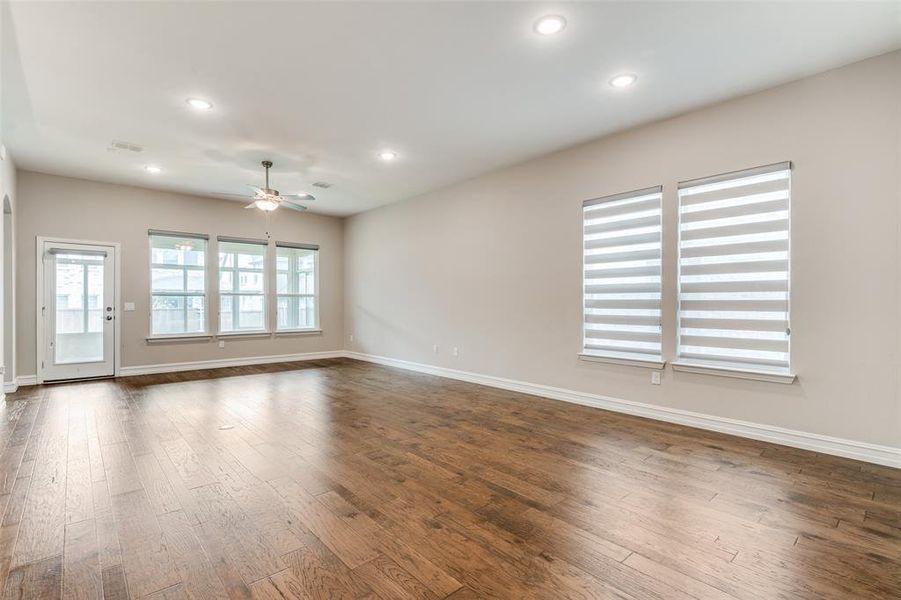 Empty room with ceiling fan and dark hardwood / wood-style floors