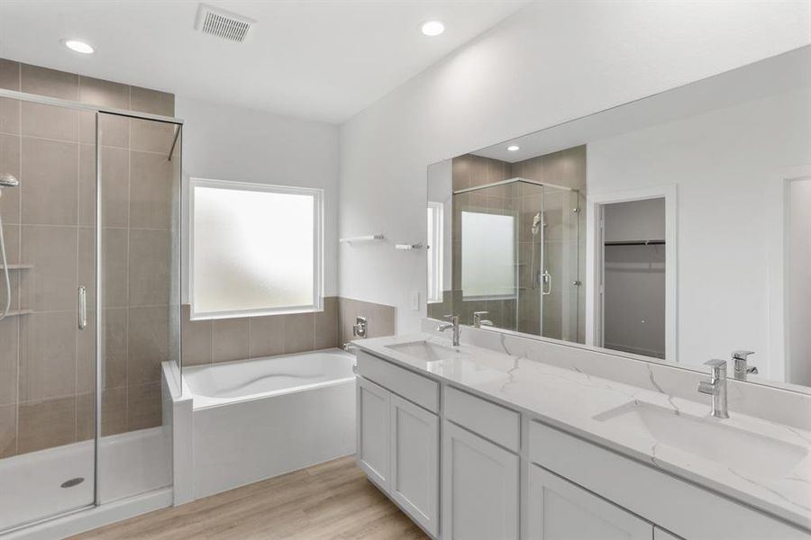 The primary bathroom is private and inviting, roomy enough to move around comfortably. Unwind in your deep soaking tub or jump in the separate shower for a quick rinse.