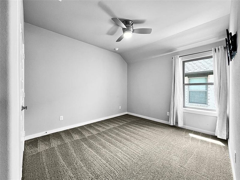 Unfurnished room with carpet flooring, lofted ceiling, and ceiling fan