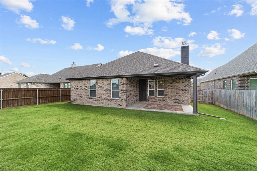 Rear view of property with a yard and a patio area