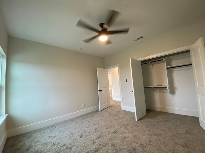 Unfurnished bedroom with carpet flooring, a closet, and ceiling fan