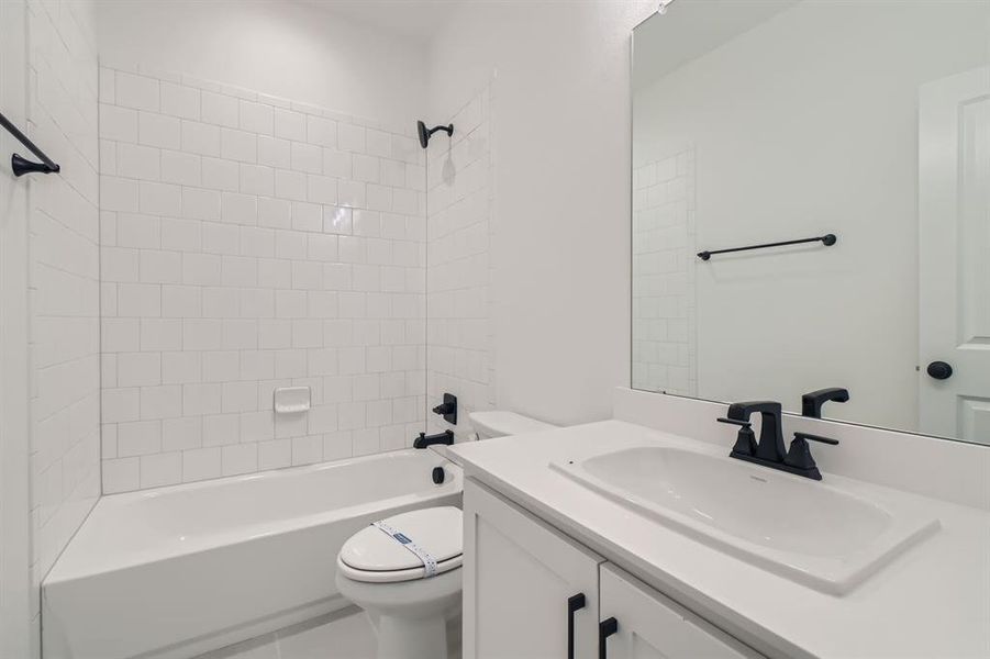 Full bathroom featuring toilet, tiled shower / bath, and vanity