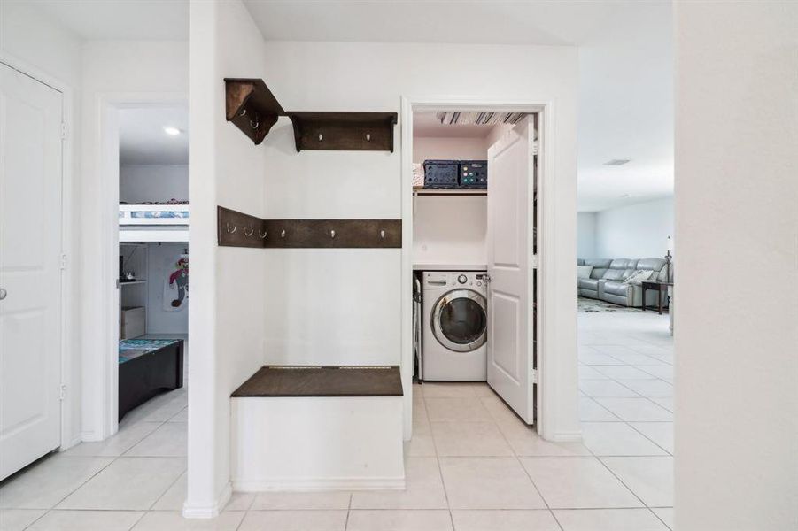 Clothes washing area featuring light tile patterned floors and washer / dryer