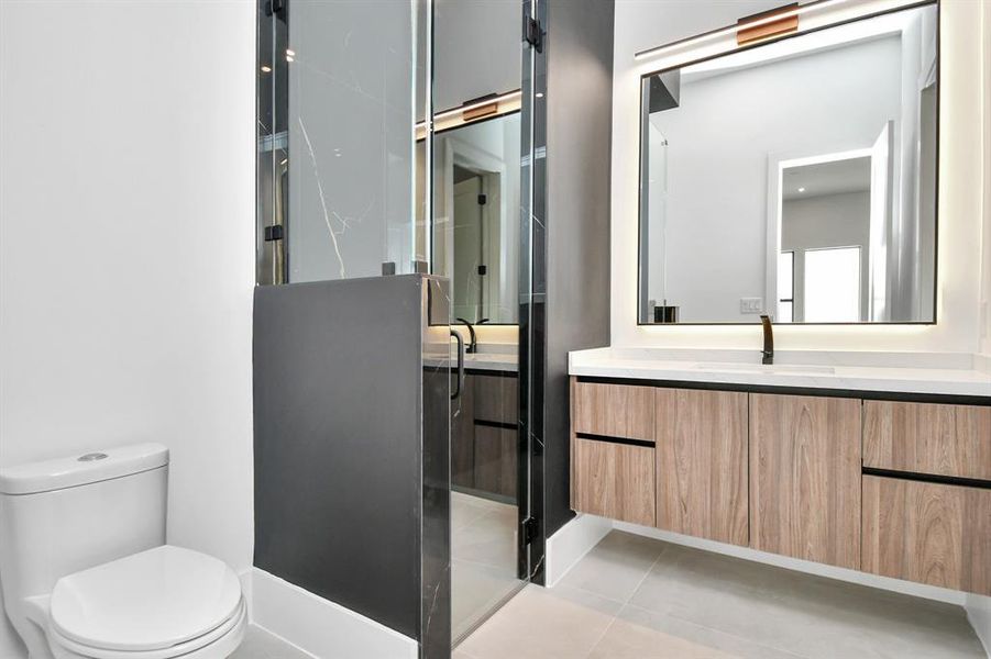 Step into luxury with this stunning bathroom featuring a spacious walk-in shower, modern hardware, and sleek tile extending from floor to ceiling.