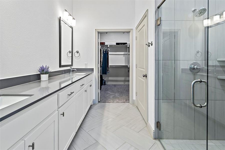 Bathroom featuring a shower with shower door and vanity