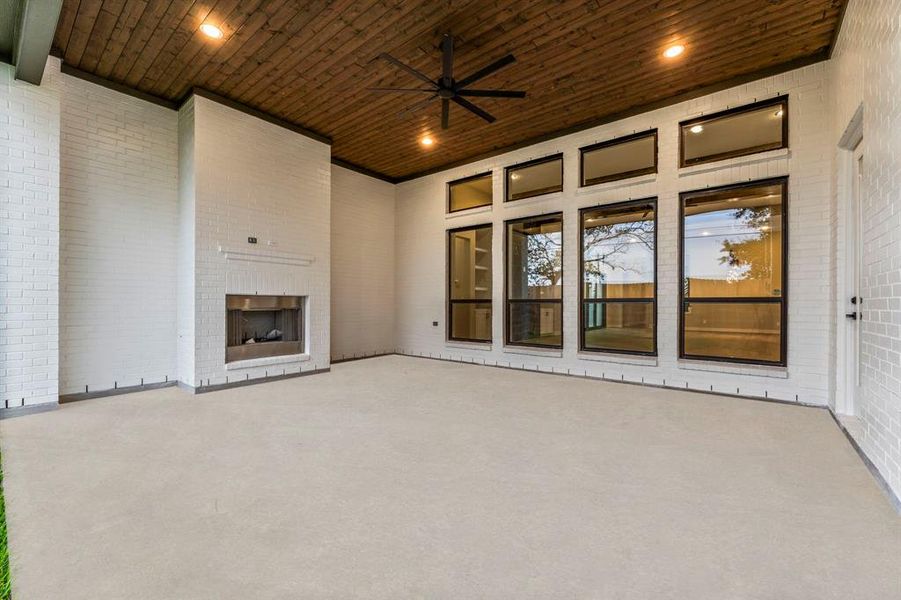 Expansive covered patio in the backyard, featuring a gas fireplace and ample space for an outdoor kitchen.