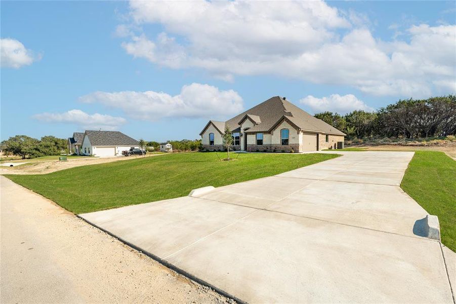 View of front facade featuring a front lawn and a garage