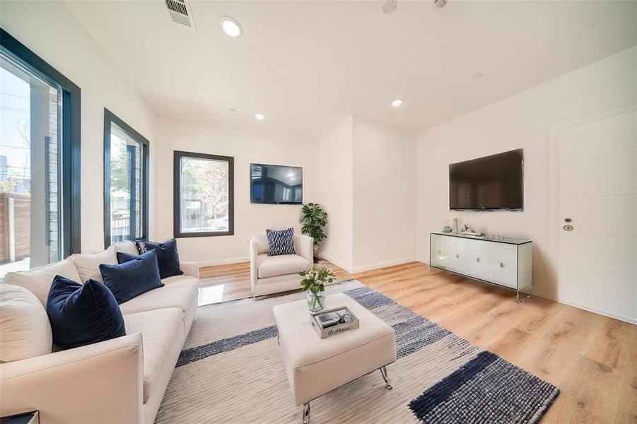 Living room with light wood-type flooring and a wealth of natural light