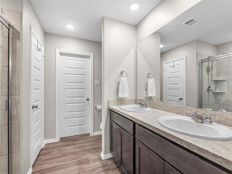 The en-suite bathroom offers a spa-like atmosphere with its elegant design, high end finishes, and tasteful lighting, creating a retreat within your own home.