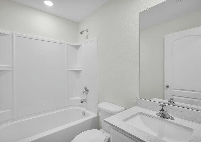 The spare bathroom has a large vanity and tub