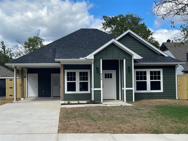 View of front facade featuring a carport and a front yard