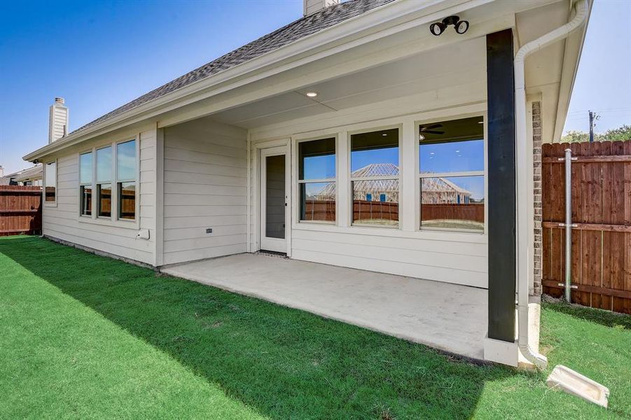 Rear view of property with a patio and a yard