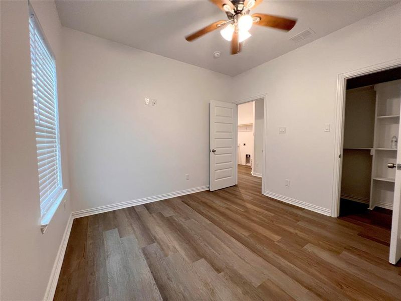 2 additional  bedrooms featuring a closet, ceiling fan, multiple windows, and hardwood / wood-style floors