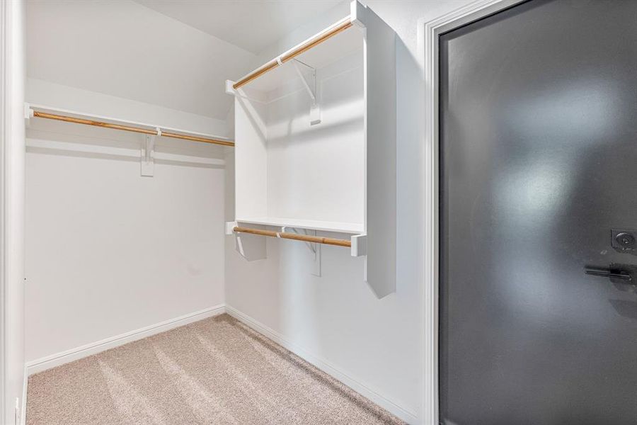 Walk in closet with light colored carpet