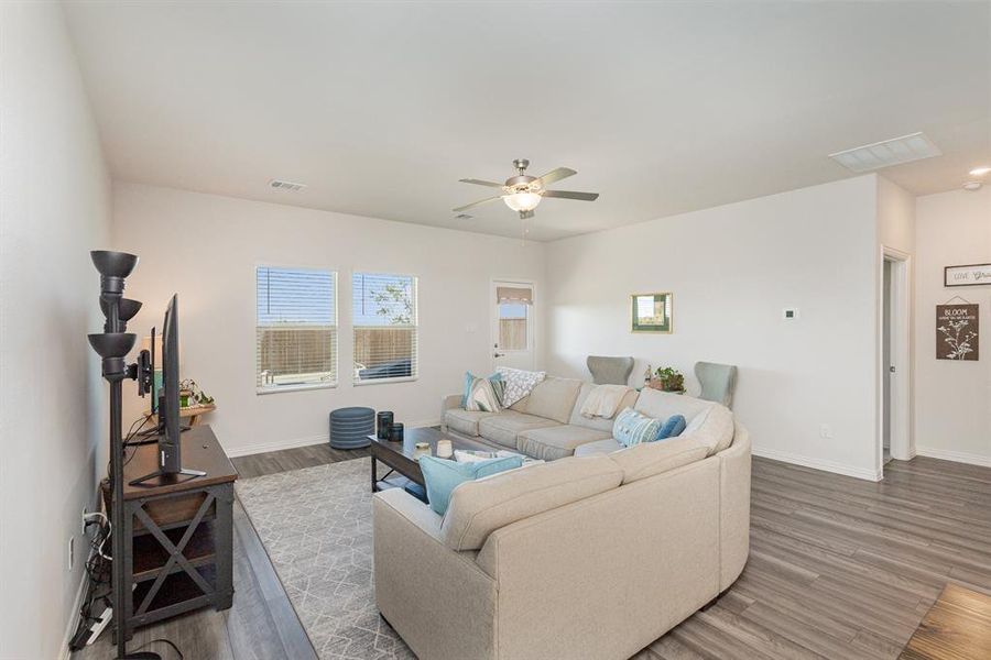 Living room featuring ceiling fan and dark wood-type flooring