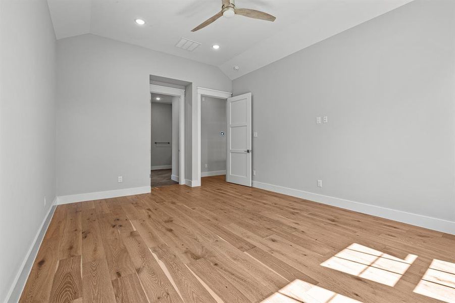 Unfurnished bedroom with lofted ceiling, a closet, ceiling fan, and light wood-type flooring