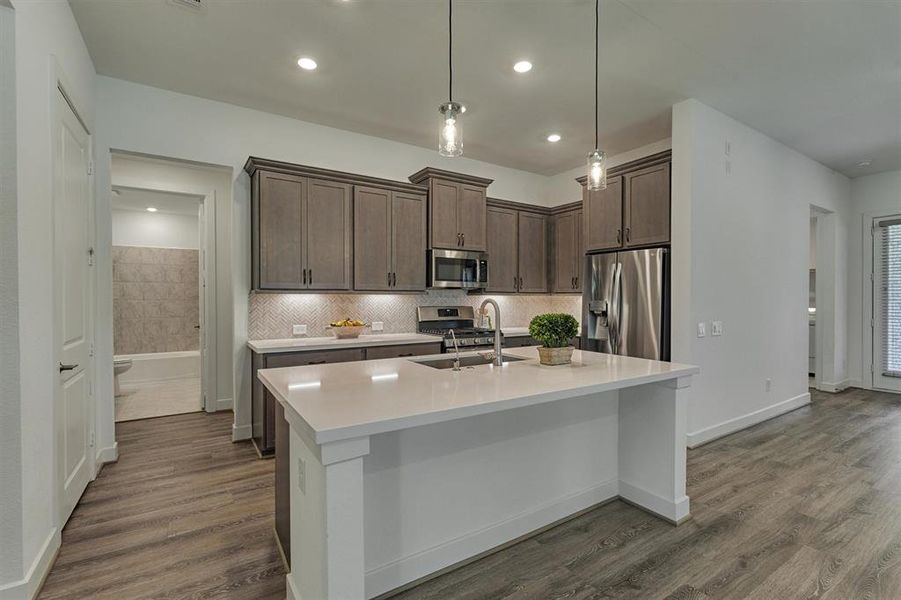 Private hall behind kitchen leads to full bath and a generous-sized secondary bedroom.