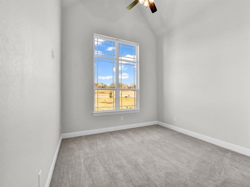 Unfurnished room with ceiling fan, carpet, and lofted ceiling