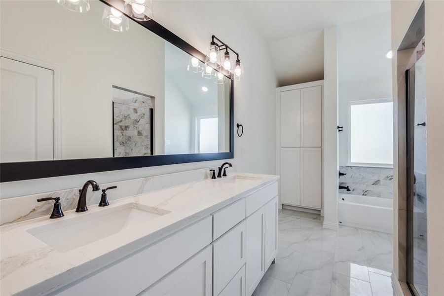 Bathroom featuring vanity, plus walk in shower, a wealth of natural light, and vaulted ceiling