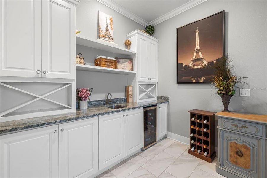 Bonus Room Offers Many Options! Includes a Kitchenette, Cabinet & Shelving Storage with Granite Countertops, Stainless Sink, Wine Refrigerator, Crown Molding, Tile Flooring & Recessed Lighting too!