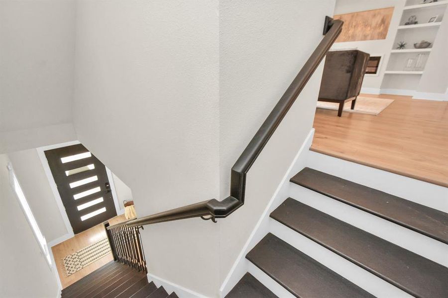 Elegant oak wood stairwell ascends to upper levels, adding timeless charm.