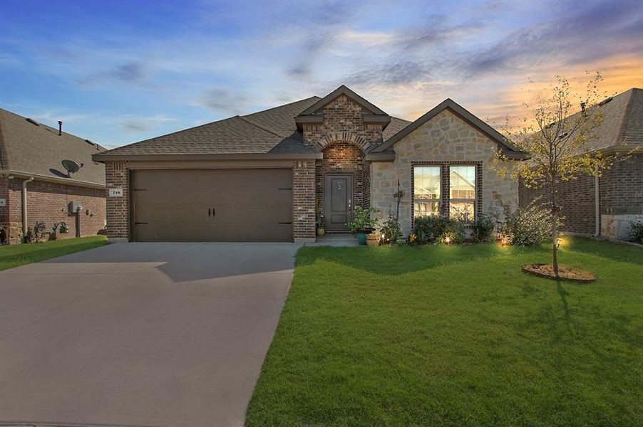 French provincial home with a garage and a lawn