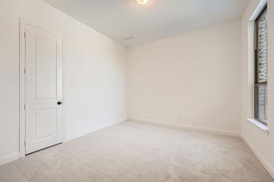 Bedroom featuring light carpet