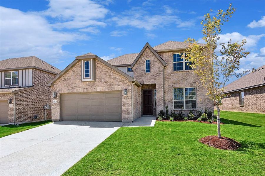 View of front of house featuring a garage and a front lawn