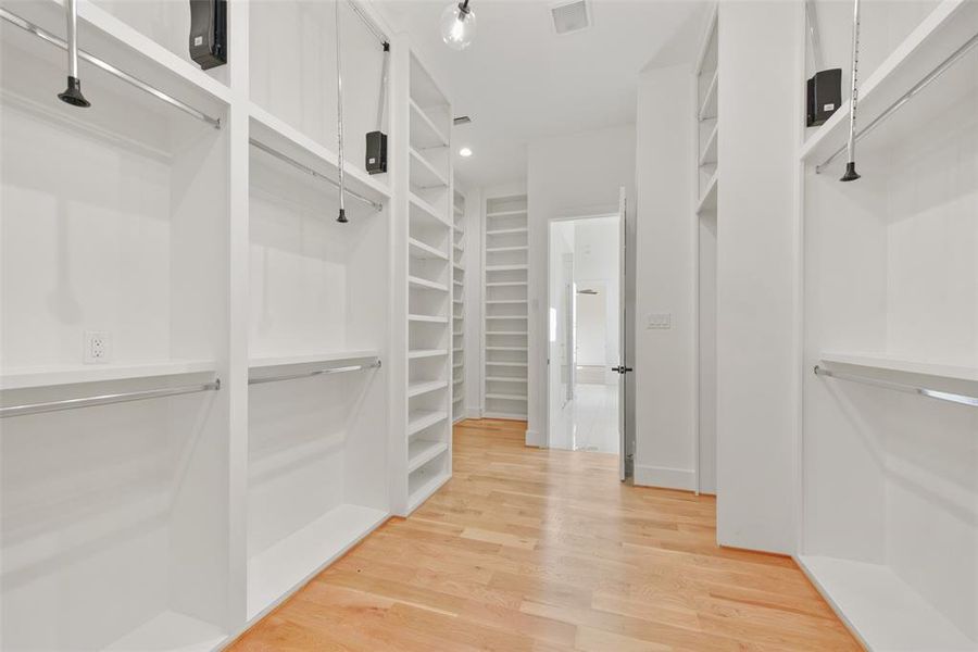 The primary closet is extensive and offers floor to ceiling built-in storage, recessed lighting in the ceiling and LED lighting in each of the built-in spaces.